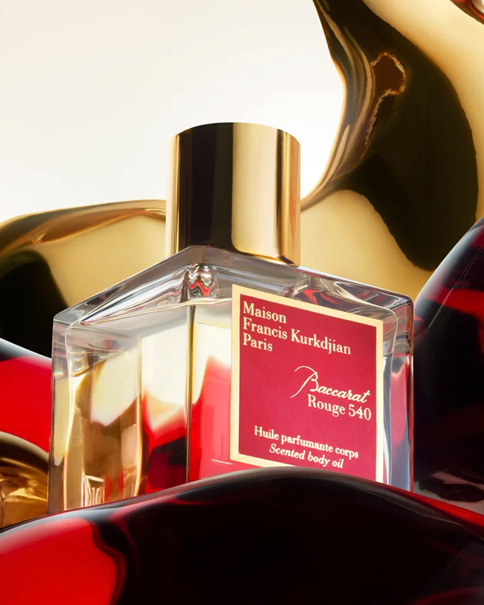 Maison Francis Kurkdjian perfume bottle with gold cap and red label.